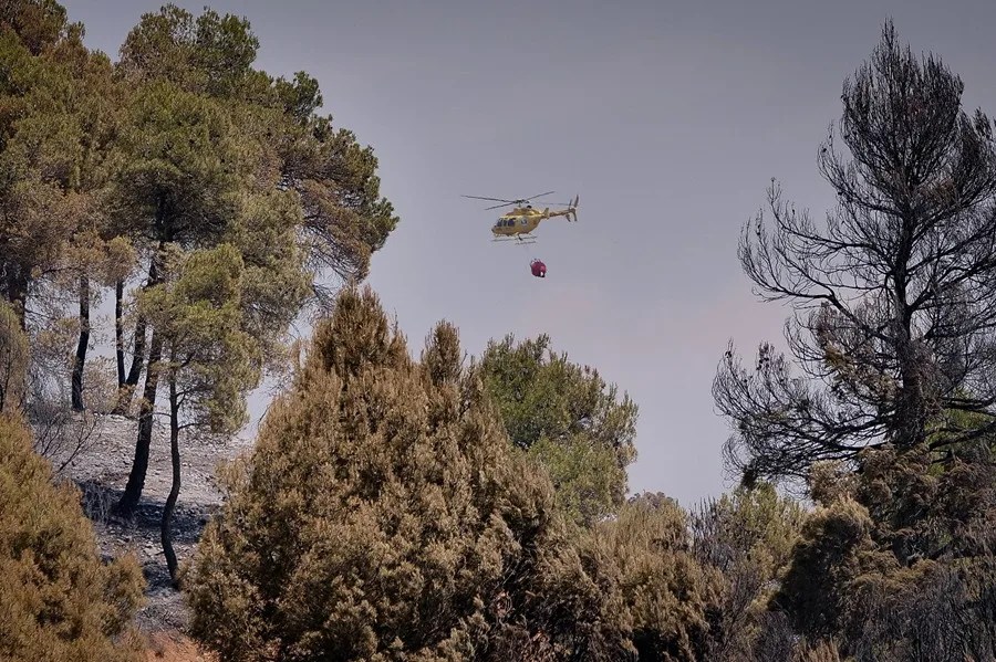 Un helicóptero trabaja en las labores de extinción del incendio declarado en Peñarroya de Tastavins en la comarca del Matarraña (Teruel)