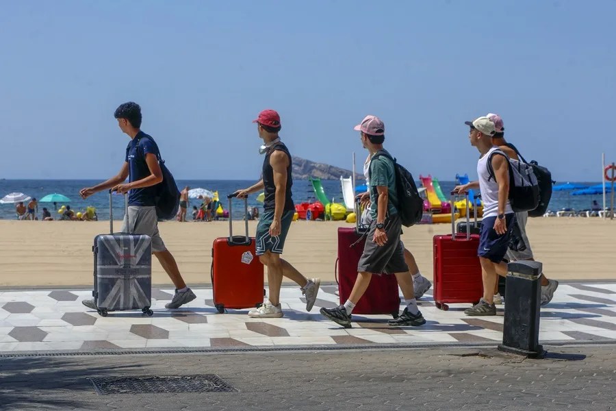 Unos turistas llegan a la playa de Benidorm (Alicante).
