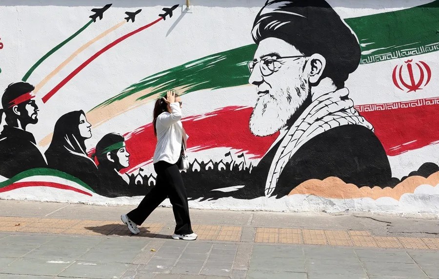 Una mujer pasa frente a un mural del fallecido líder supremo iraní, el ayatolá Ali Jamenei, en Teherán