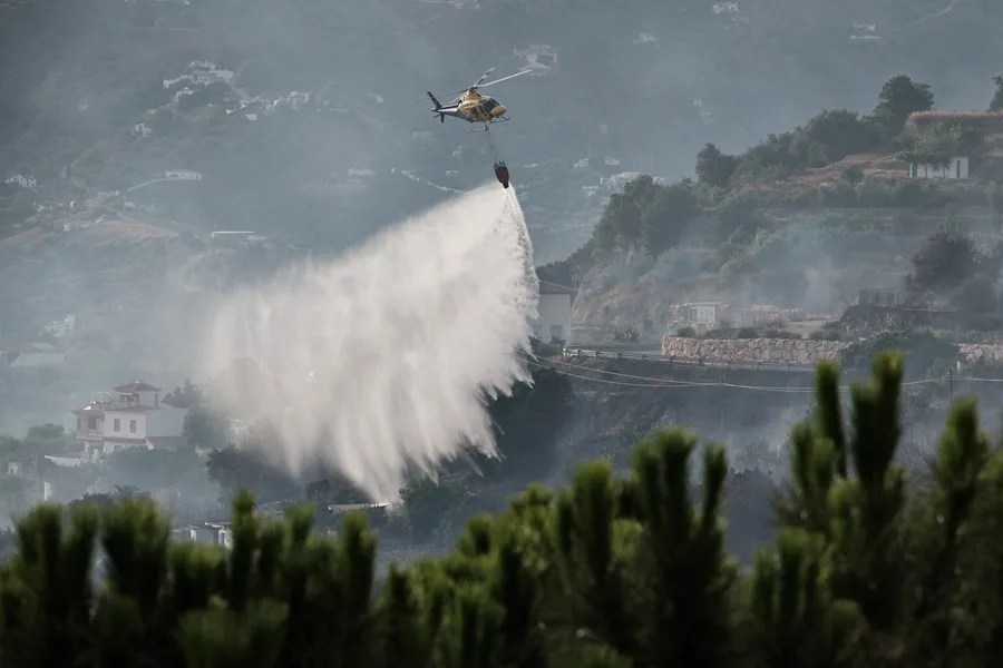 Un momento de las labores de extinción este viernes del incendio forestal entre las poblaciones malagueñas de Archez y Competa. 
