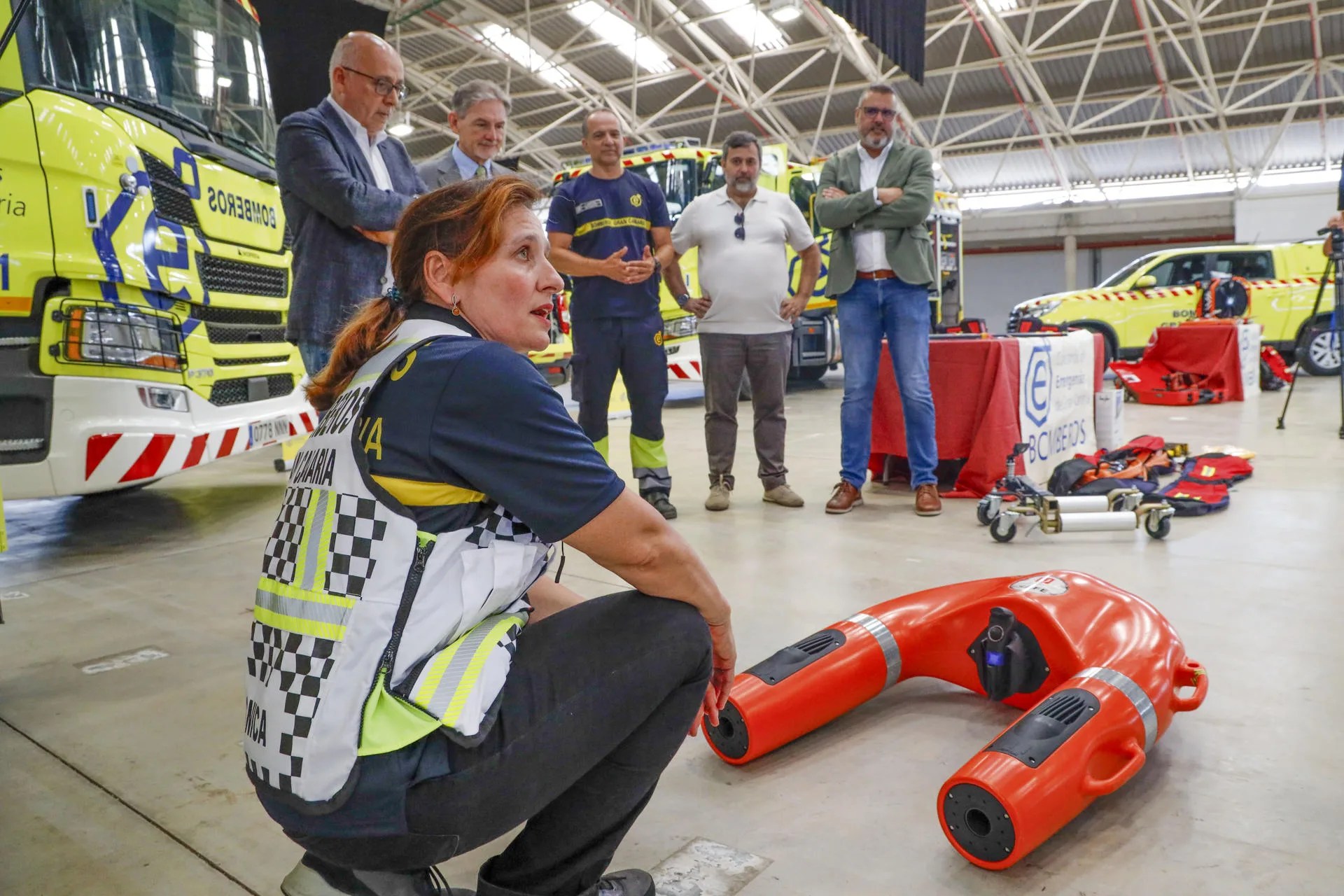 El presidente del Cabildo de Gran Canaria, Antonio Morales (2i), y el consejero de Hacienda, Pedro Justo (3i), presentaron este martes los nuevos vehículos del Consorcio Insular de Emergencias, que incorpora además drones acuáticos y robots de extinción de incendios. En la imagen, la técnica de Gestión del Riesgo Zulema Villar (i) durante la presentación. EFE/ Laura Bautista