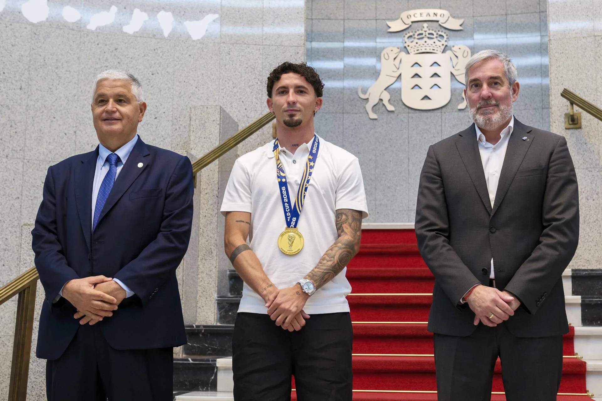 El presidente del Gobierno de Canarias, Fernando Clavijo (d), y el presidente de la Federación Interinsular de Fútbol de Las Palmas, José Juan Arencibia (i), durante la recepción este lunes al campeón del mundo de fútbol Yeremy Pino (c). EFE/Ángel Medina G.