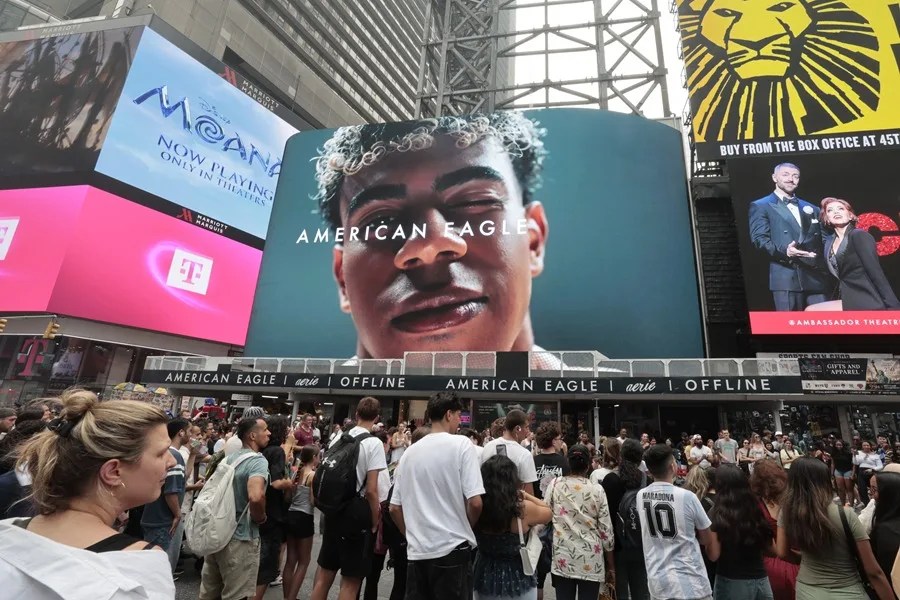 Personas caminan frente a un cartel luminoso con la imagen de Lamine Yamal de España en Times Square.