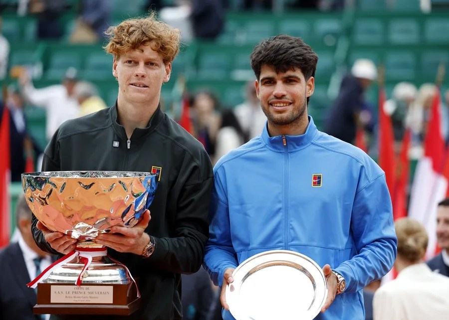Jannik Sinner, de Italia (izq.), y Carlos Alcaraz, de España (der.), posan con sus trofeos después de que Sinner ganara la final individual masculina del torneo de tenis ATP Masters de Montecarlo