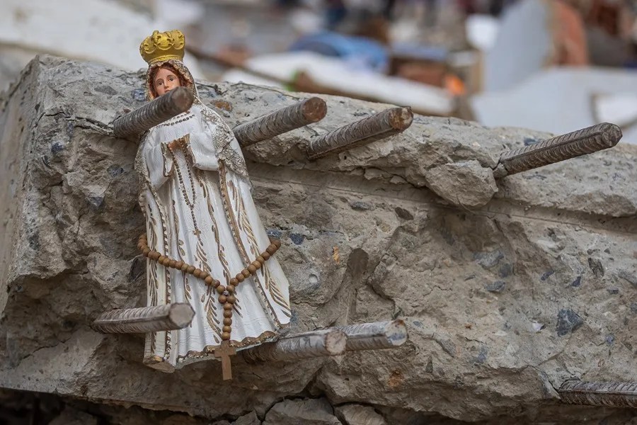 Fotografía que muestra una imagen religiosa entre los escombros de edificios que colapsaron durante los terremotos en La Guaira
