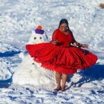 Una mujer aymara reacciona junto a un muñeco de nieve en La Cumbre (Bolivia).