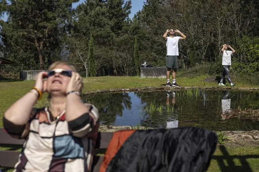 Varias personas observan un eclipse.