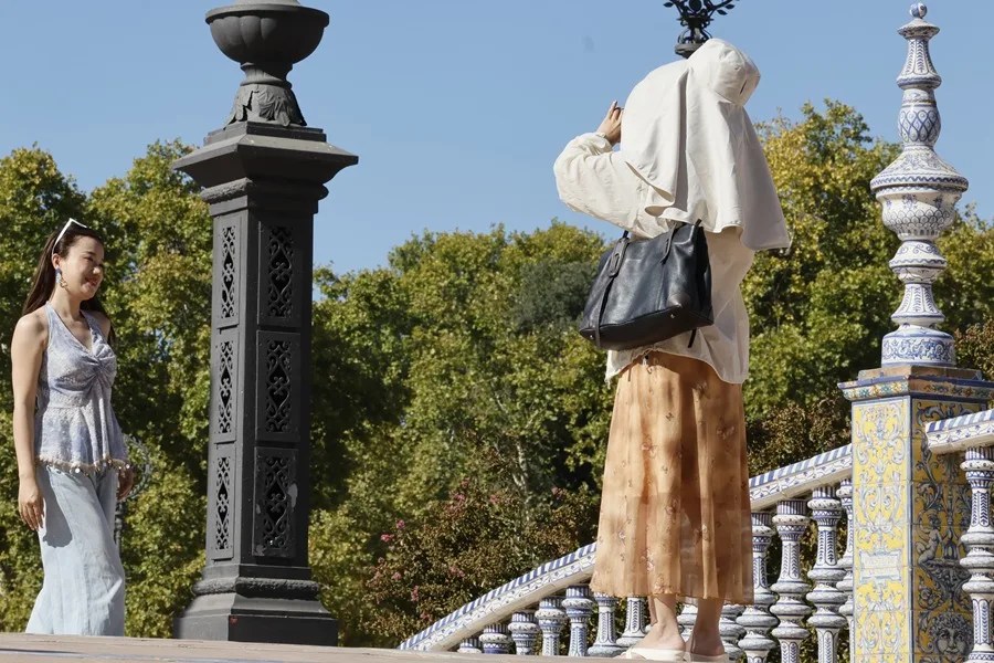 Turistas se toman fotos en la Plaza de España en Sevilla.