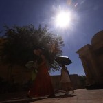 Turistas se protegen con paraguas para aliviar las altas temperaturas