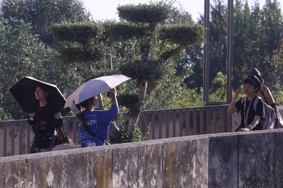 Unas turistas se protegen con paraguas de las altas temperaturas en Córdoba.