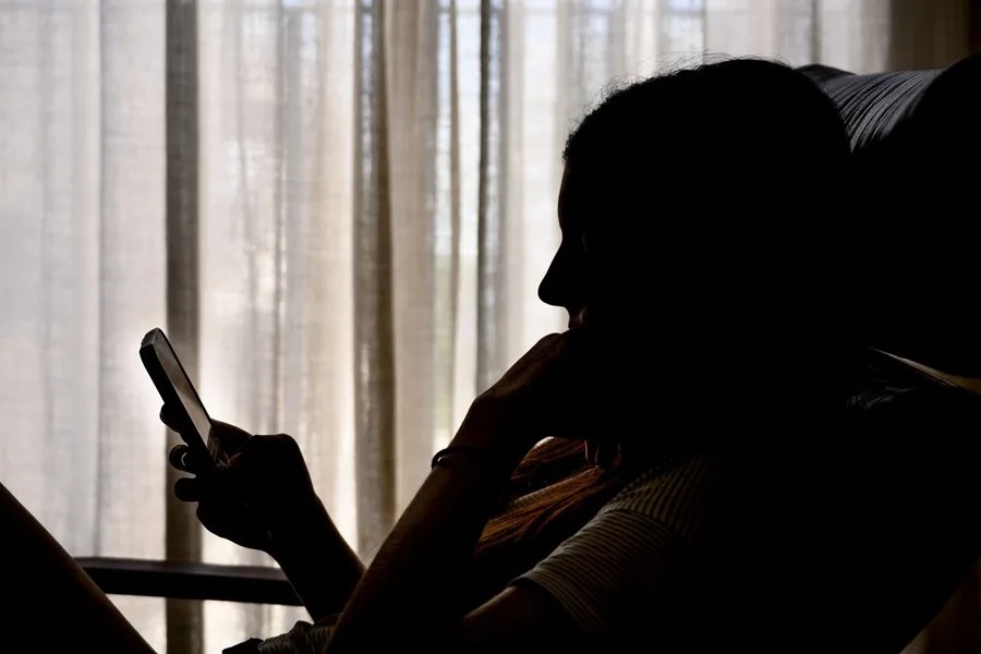 Una adolescente consulta una red social en su móvil.
