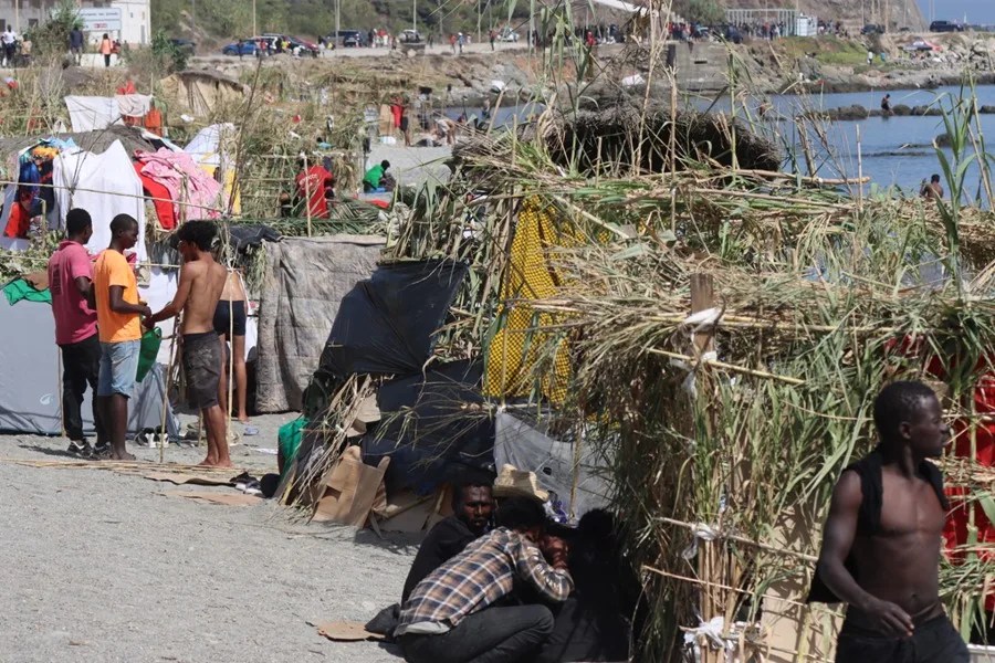 Migrantes en la playa del Trampolín, transformada en un asentamiento, en Ceuta.