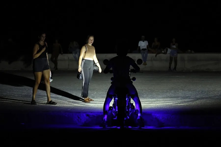 Personas caminan durante un apagón este sábado, en La Habana (Cuba).