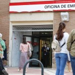 Varias personas hacen cola para acceder a una oficina de empleo en Madrid.