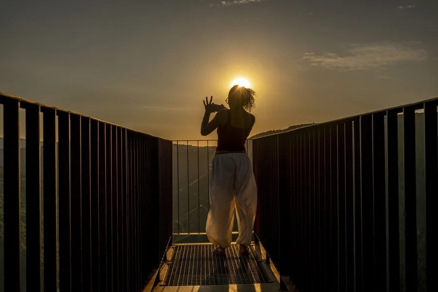 Una mujer toma fotografías del atardecer y del Cañón del río Sil desde el Mirador de Matacás, en Castro Caldelas (Ourense).