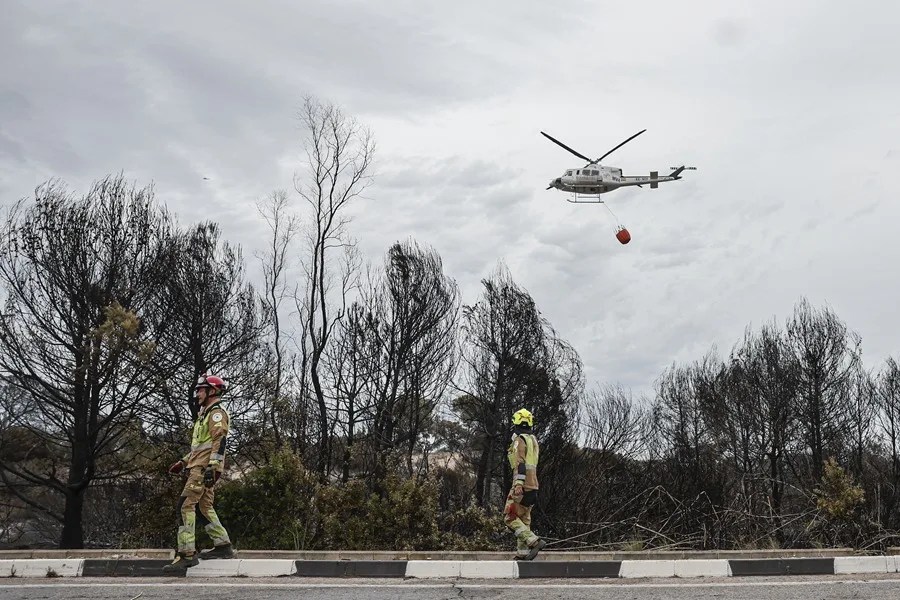 Un helicóptero realiza una descarga de agua en la zona mas afectada por las llamas en El Saler.