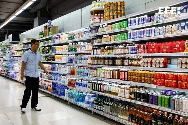 Un hombre mira una estantería de un supermercado en Pekín.