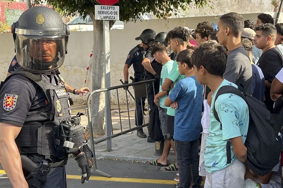 Multitud de menores migrantes esperan para su filiación frente a la Jefatura Superior de la Policía Nacional en Ceuta.
