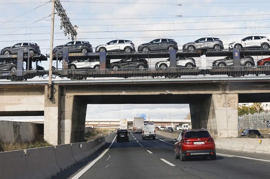 Un tren con un cargamento de coches a su paso por la circunvalación de Valencia.