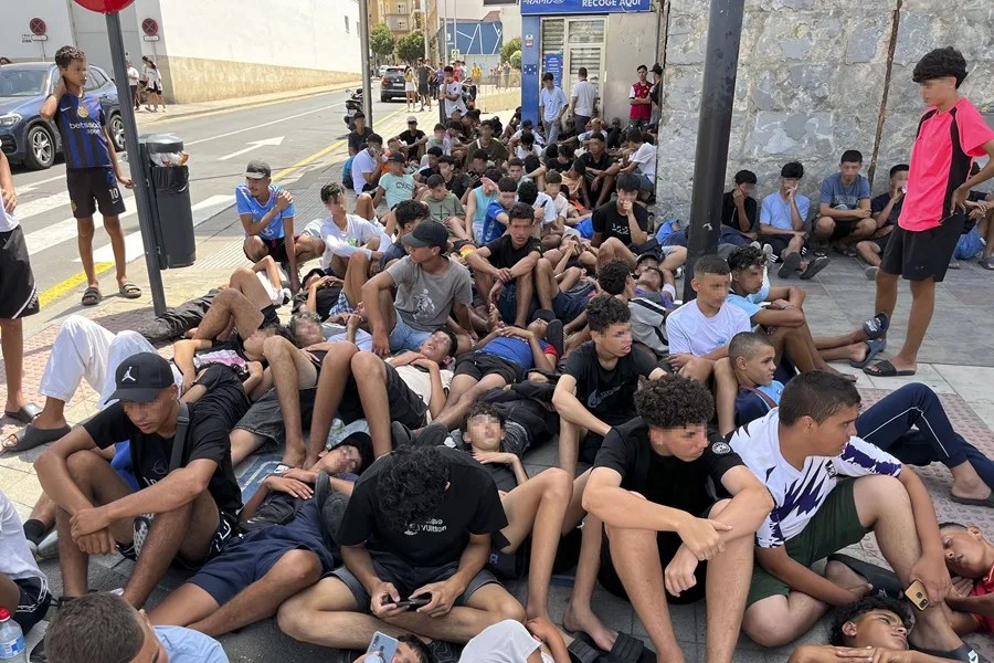 Multitud de menores migrantes esperan para su filiación frente a la Jefatura Superior de la Policía Nacional en Ceuta