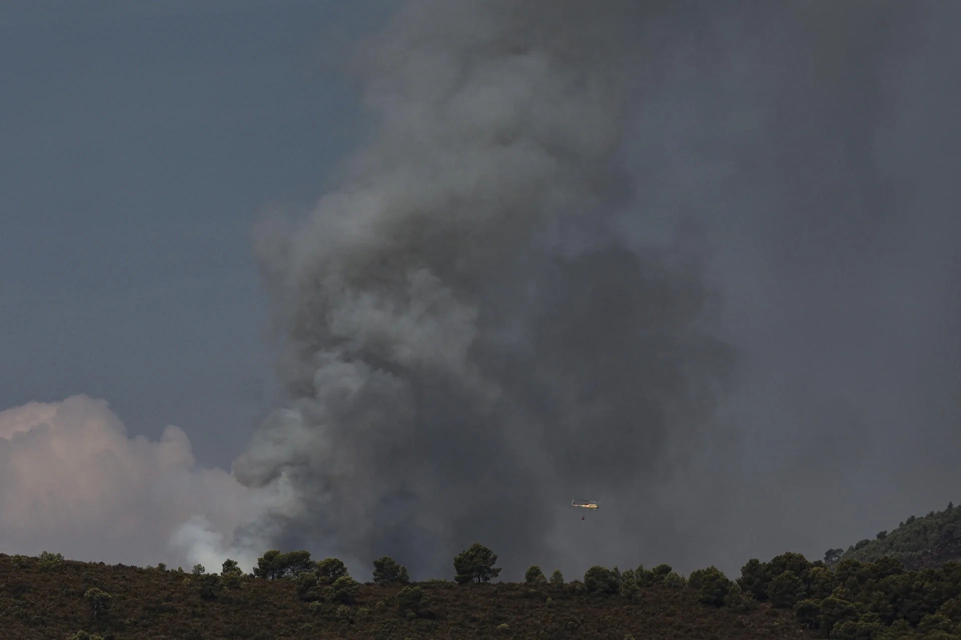 Un helicóptero sobrevuela el frente del incendio forestal declarado en Segorbe (Castellón).
