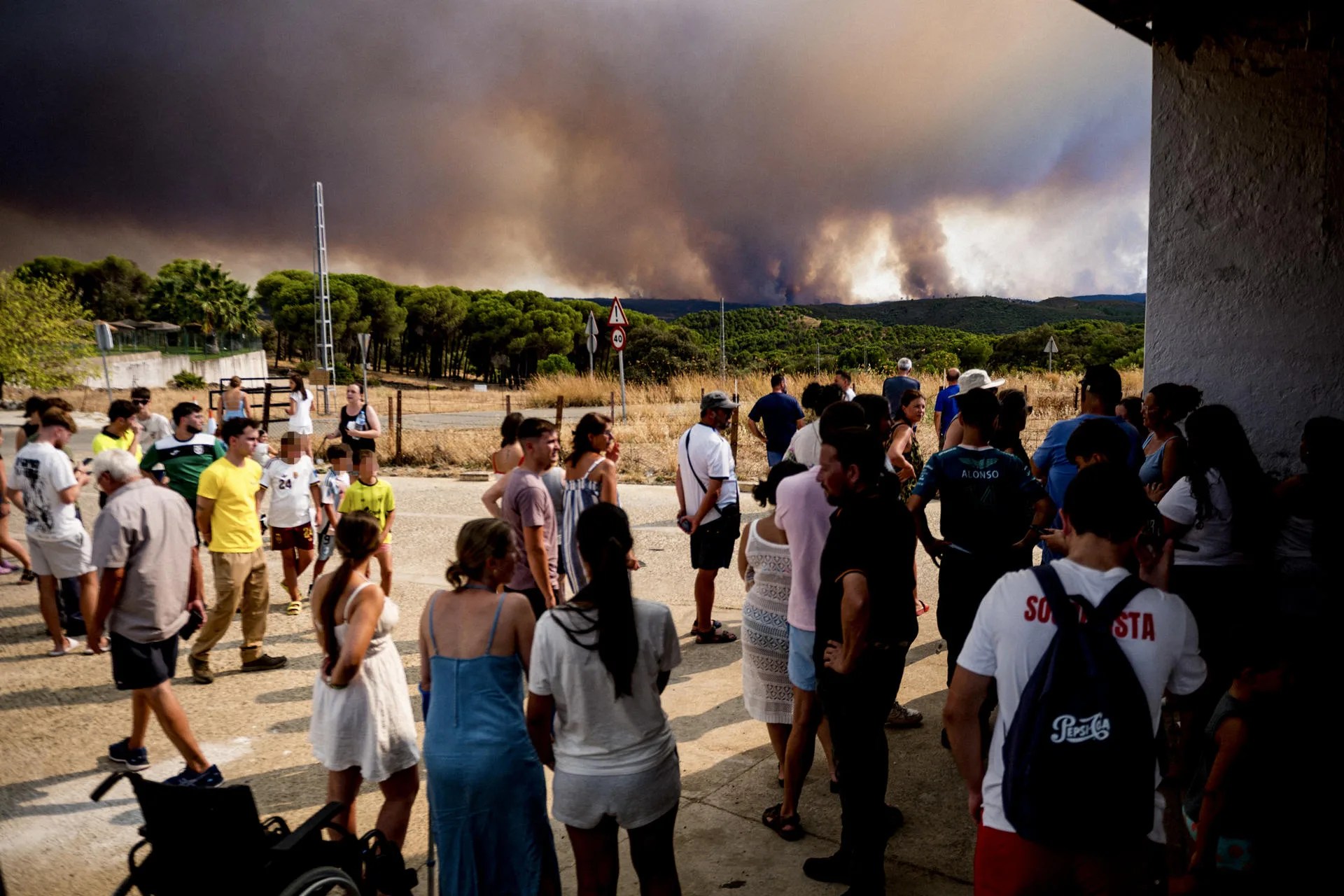 Vecinos de El Madroño, en Sevilla, observan este domingo el fuego del incendio de Niebla (Huelva), que ha recorrido un perímetro de 44 kilómetros con unas 8.000 hectáreas, presenta dos frentes activos y mantiene desalojadas a un total de 467 personas. EFE/Mauri Buhigas
