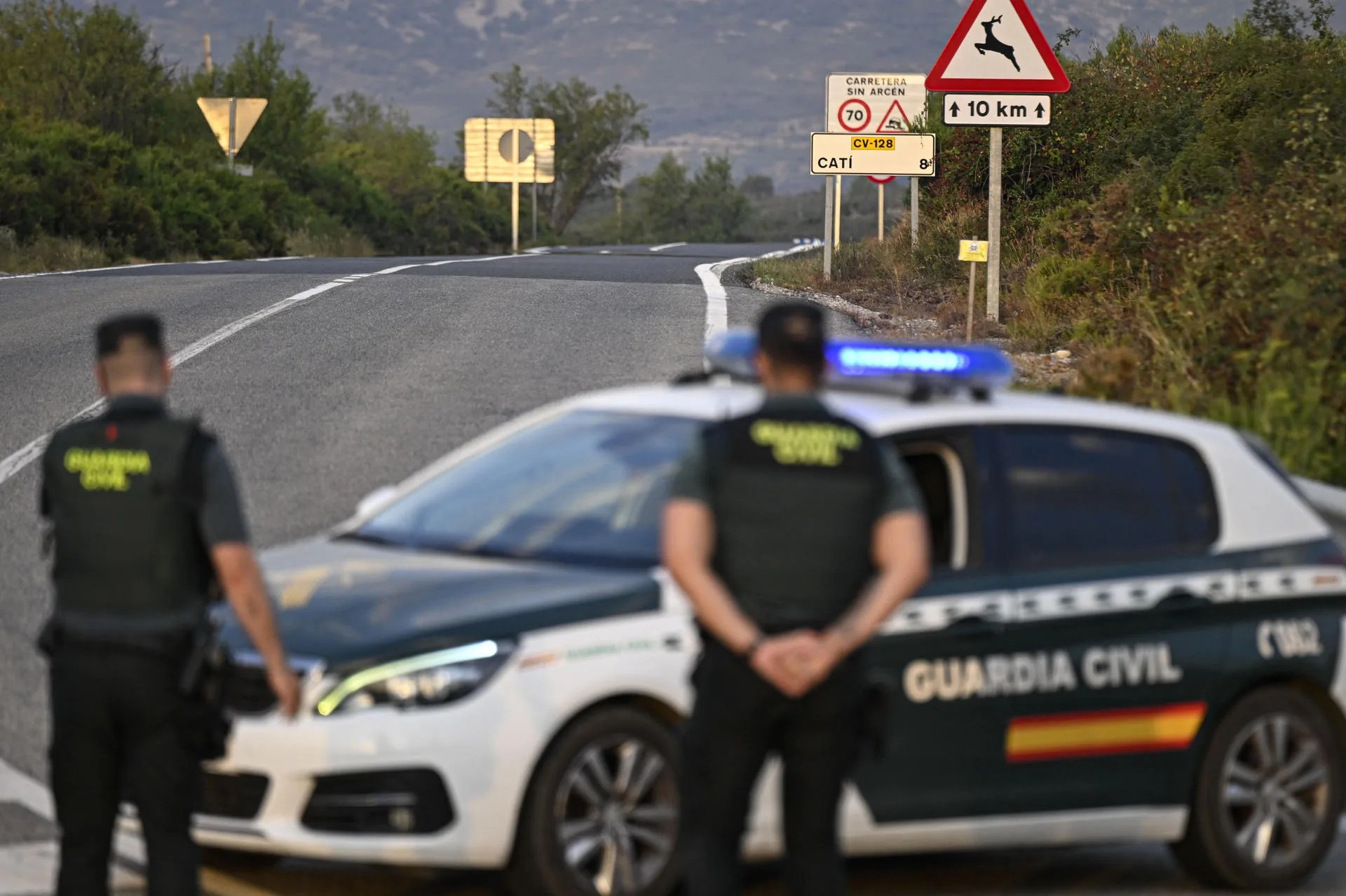 Agentes de la Guardia Civil controlan los accesos por carretera a la población de Catí (Castellón), que ayer fue desalojada preventivamente por el avance del incendio forestal de Tírig, declarado el pasado viernes a última hora de la tarde. EFE/Andreu Esteban
