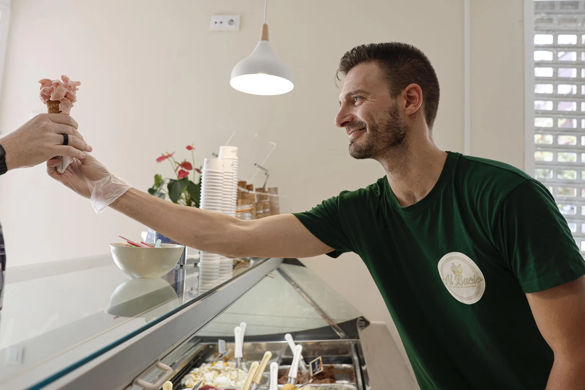 Diego Salvati, propietario de la heladería italiana Al Bacio, da a probar un cucurucho con su helado La Tomatina, un helado de tomate en honor a esta fiesta que este año estará disponible para celebrar una nueva edición de este festival que se ha hecho famoso en todo el mundo. EFE/Manuel Bruque