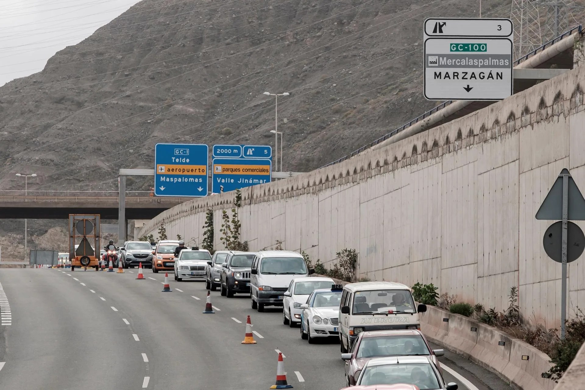Imagen de archivo. Una larga fila de vehículos cruza por el único carril habilitado para circular por el tramo de la autovía GC-1 tras producirse el derrumbe de un muro de contención en la entrada a Las Palmas de Gran Canaria, lo que llegó a provocar colas de más de 20 kilómetros en el acceso a la ciudad el 12 de diciembre de 2019. EFE/ Ángel Medina G.