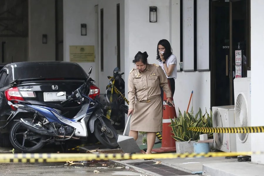 Funcionarios de la Organización Administrativa Provincial inspeccionan el lugar de un tiroteo ocurrido frente a la sede de dicha organización en la provincia de Nonthaburi, Tailandia.