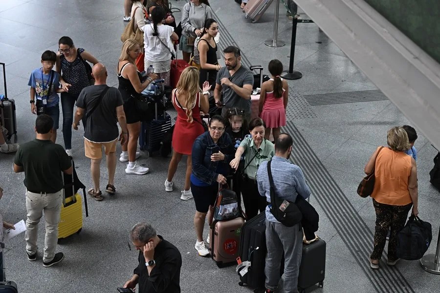Varios pasajeros aguardan la salida de su tren en la Estación de Atocha, en Madrid.