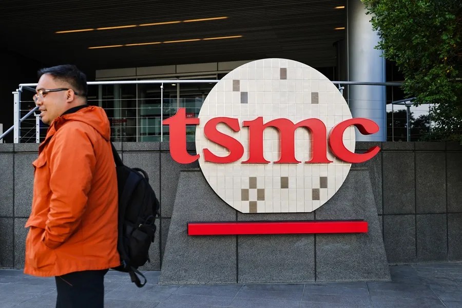 Una persona pasa junto al logo de la empresa TSMC en Taiwán.