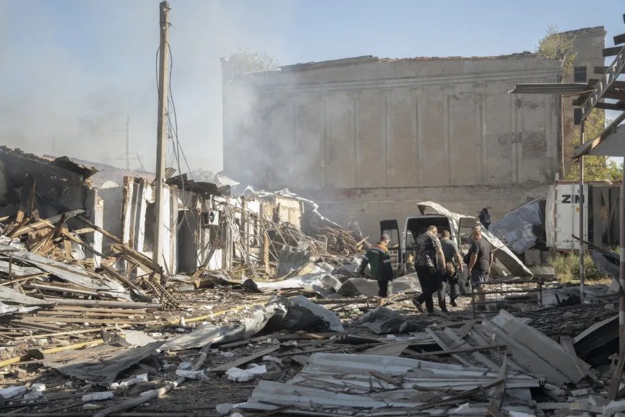 Residentes locales inspeccionan el lugar de un ataque aéreo ruso que impactó contra un almacén en Donetsk, Ucrania