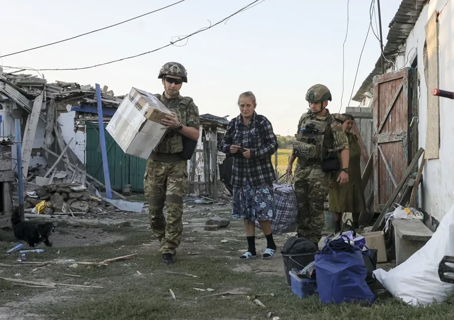 Policías ucranianos y voluntarios de la organización pública "Chaplain Patrol" evacúan a personas mayores de localidades situadas en la línea del frente en la región de Zaporiyia.