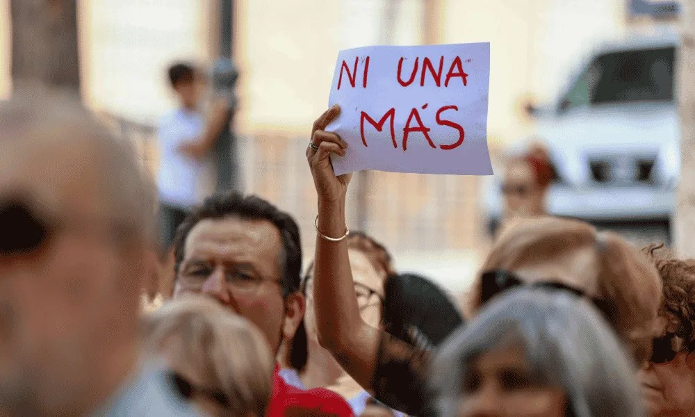 Una mujer muestra un cartel en el que se puede leer 'ni una más' durante un acto de repulsa contra la violencia machista.