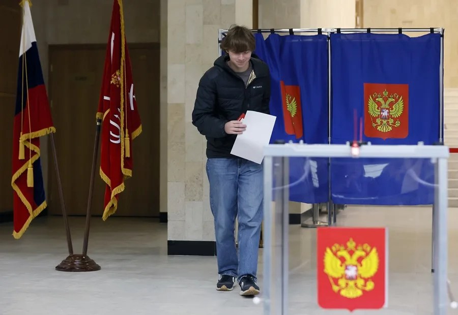 Varios votantes depositan sus papeletas en un colegio electoral en San Petersburgo, Rusia.