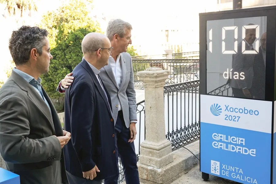 El presidente de la Xunta, Alfonso Rueda, junto al comisario del Xacobeo, Marcos Gómez, (i) y el deán de la catedral de Santiago, Manuel Jesús Formoso, observan la puesta en marcha del Cronómetro Xacobeo