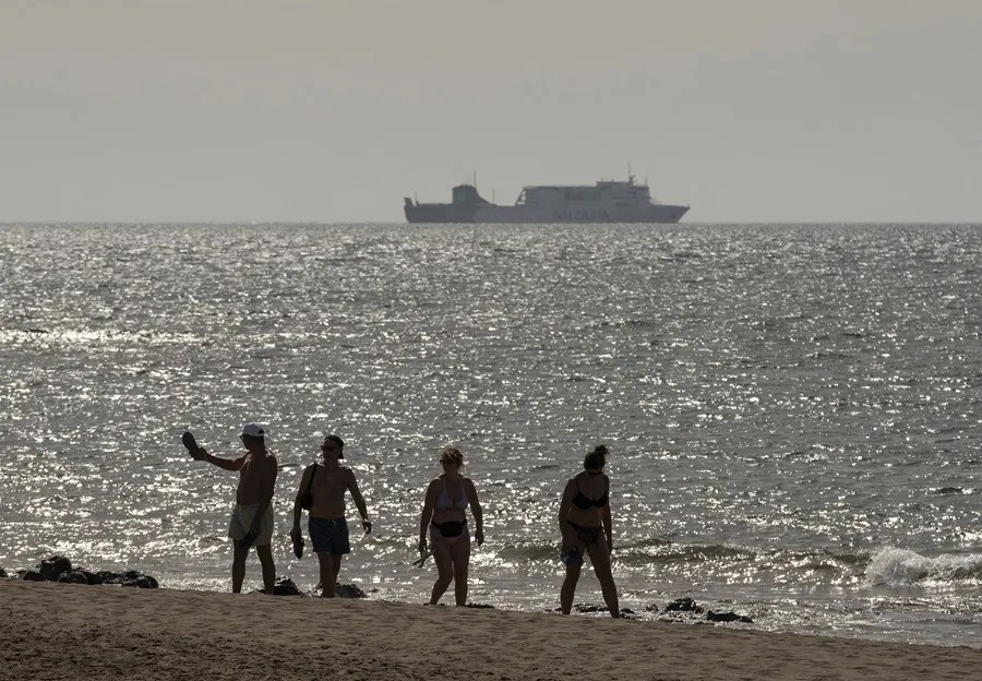 Varios turistas disfrutan de un día de playa en Puerto del Carmen (Lanzarote).