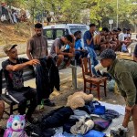 Un migrante que se dedica a vender artículos en puestos ambulantes que se han levantado en la playa de El Trampolín de Ceuta