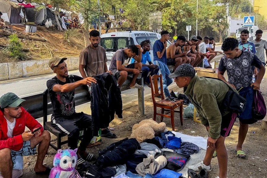 Un migrante que se dedica a vender artículos en puestos ambulantes que se han levantado en la playa de El Trampolín de Ceuta