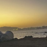 Un migrante reza al amanecer en la playa del Trampolín en Ceuta.