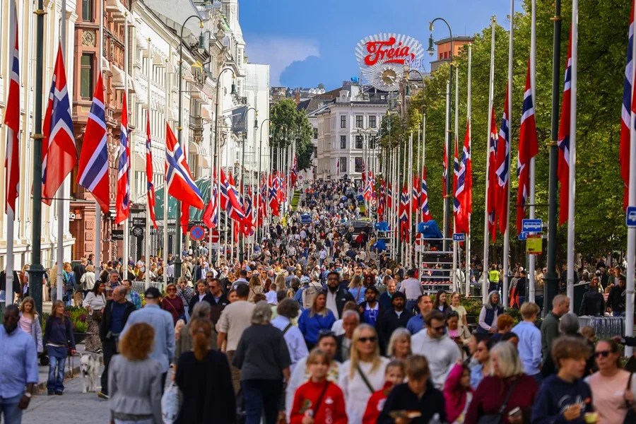 Personas se reúnen en la calle Karl Johans, adornada con banderas noruegas a media asta tras la muerte del rey Harald V, en Oslo