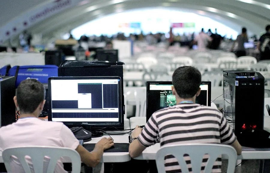 Dos personas trabajan en sus ordenadores