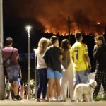 Vecinos de una localidad observan el incendio cerca de sus casas.