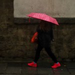 Una mujer se protege de la lluvia con un paraguas
