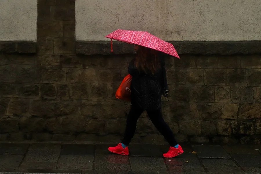 Una mujer se protege de la lluvia con un paraguas