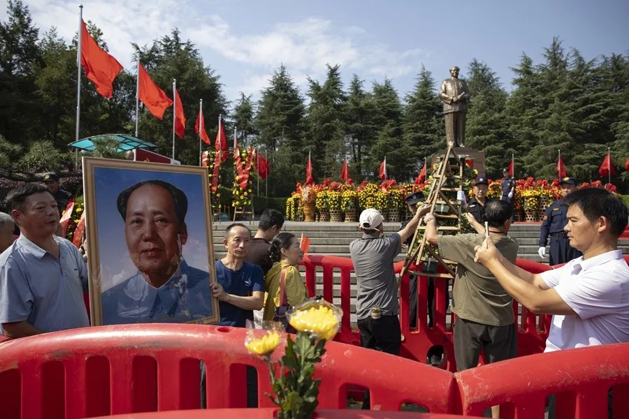 Asistentes portan un retrato de Mao Zedong, durante las conmemoraciones del 50.º aniversario de su muerte en Shaoshan, China.