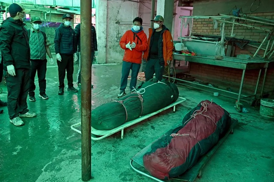 Amigos y familiares reaccionan a la llegada de los cuerpos de dos víctimas de una avalancha al Hospital Universitario Tribhuvan de Katmandú