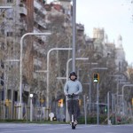 Conductor de un patinete eléctrico circula por una calle de Barcelona.