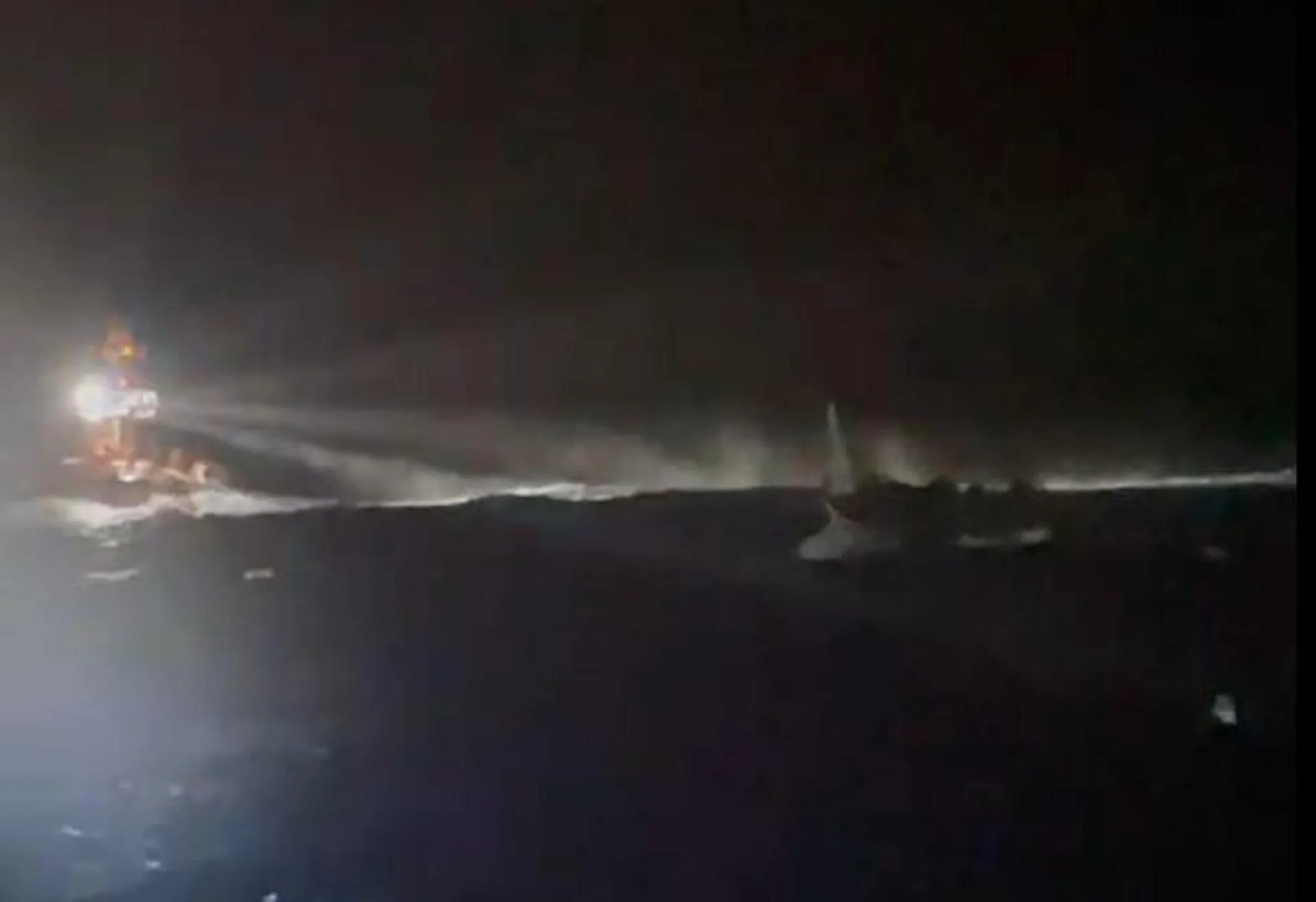 Captura de un vídeo facilitado por Salvamento Marítimo con el rescate del cayuco entre un fuerte viento y oleaje. EFE
